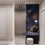 Nowoczesna aranżacja przedpokoju z granatową tapetą w suszone rośliny, szarą konsolą i białą marmurową podłogą.