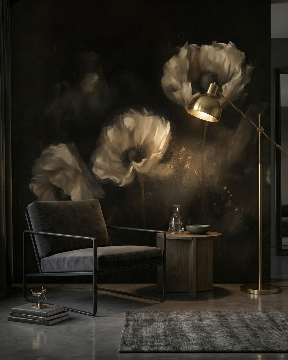 Tapeta czarna z białymi kwiatami. Nowoczesne, ciemne wnętrze salonu w formacie pionowym. Dominującym elementem jest fototapeta na czarnym tle przedstawiająca trzy duże, artystycznie rozmyte kwiaty w odcieniach złamanej bieli i szarości. Po lewej stronie stoi niski, minimalistyczny fotel z ciemnoszarą tapicerką na czarnym, metalowym stelażu. Obok fotela znajduje się okrągły, drewniany stolik z szklaną karafką. Po prawej stronie kompozycję domyka smukła, złota lampa podłogowa, której światło ciepło oświetla fragment tapety i podłogę. Na dole widoczny jest fragment teksturalnego, szarego dywanu.