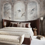 Luksusowa sypialnia z muralem przedstawiającym kamienne arkady i dymówki na tle jasnego, zachmurzonego nieba. Fototapeta premium w stylu klasycznym. Tapeta z Arkadami i Dymówkami